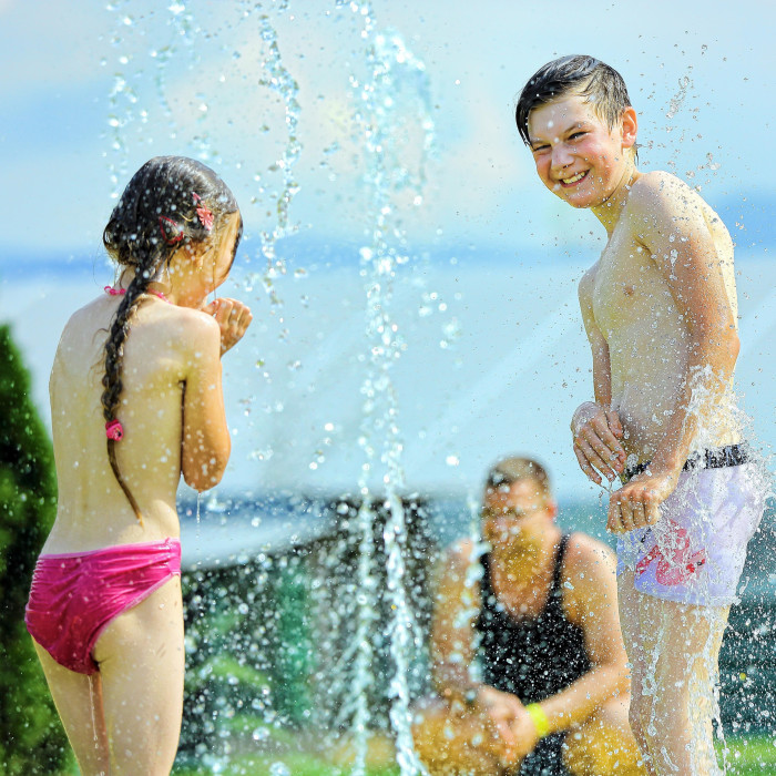 Deti hrajúce sa spolu medzi vystrekujúcimi fontánkami